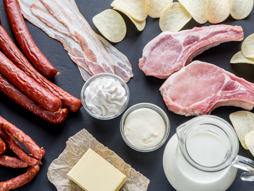 Table covered with bacon, pork chops, butter, heavy cream and sour cream